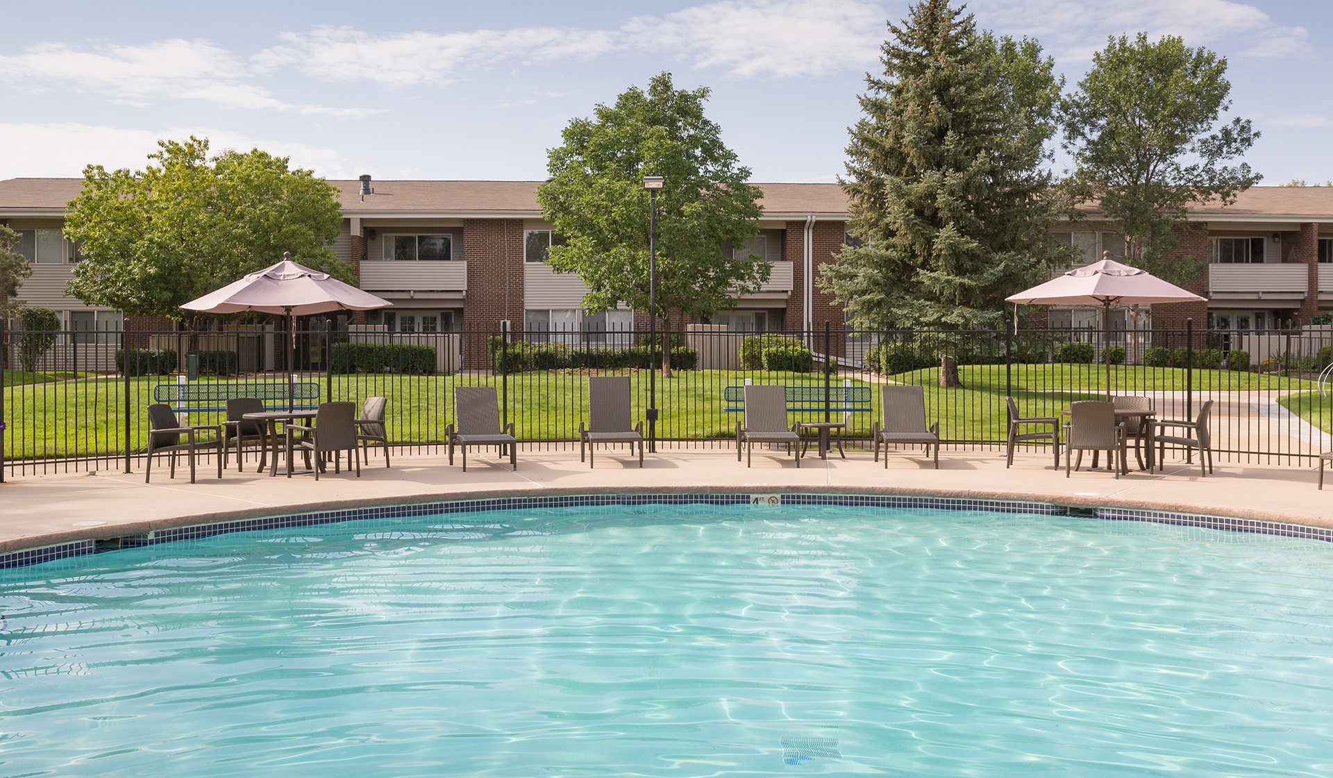 Shaded tables surrounding the pool