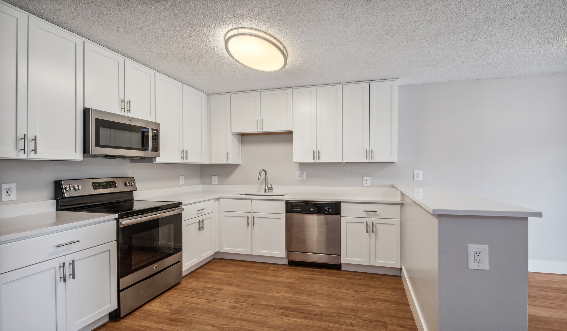 Kitchens offer stainless steel appliances and wood flooring